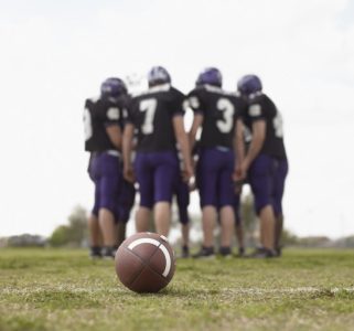 Teenage boys (16-18), football players in huddle on field Teenage boys (16-18), football players in huddle on field