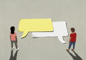 Couple talking, looking down at communication speech bubbles