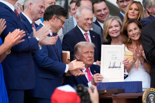 WASHINGTON, DC - JULY 04: President Donald Trump holds up the "One, Big Beautiful Bill" Act that was signed into law as during an Independence Day military family picnic on the South Lawn of the White House on July 04, 2025 in Washington, DC. After weeks of negotiations with Republican holdouts Congress passed the One, Big Beautiful Bill Act into law. The bill makes permanent President Donald Trump’s 2017 tax cuts, increases spending on defense and immigration enforcement and temporarily cuts taxes on tips, while cutting funding for Medicaid, food assistance and other social safety net programs. (Photo by Alex Brandon - Pool/Getty Images)