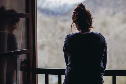 Rear view of woman in the window looking down